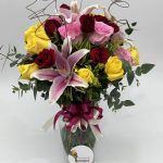Florero en agua con lirios y rosas